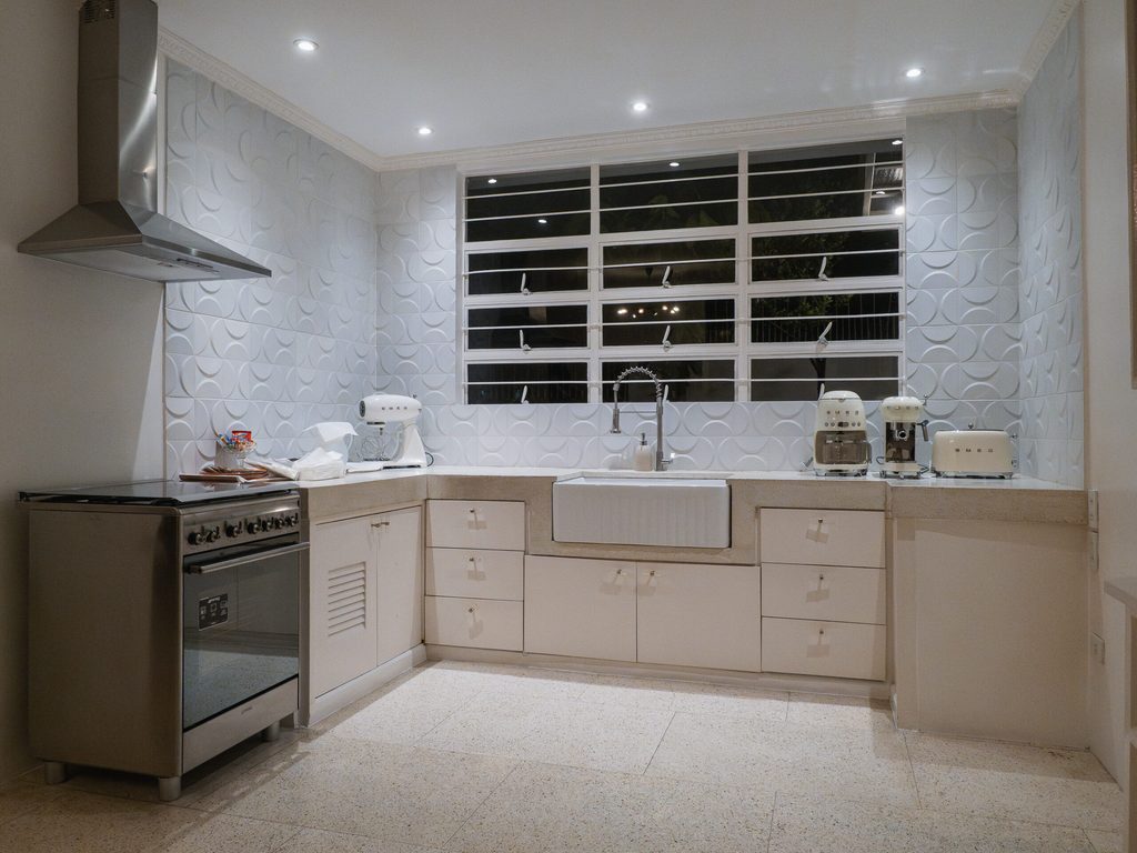 Modern kitchen with white textured tiles and Smeg appliances