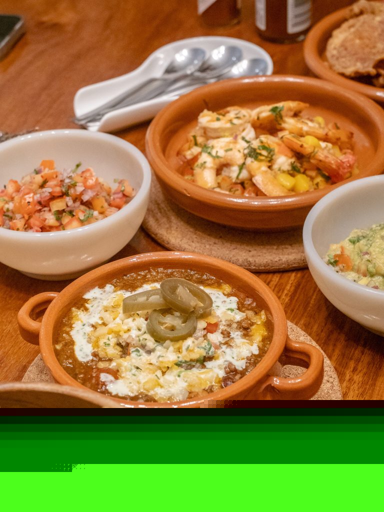 Family-style food spread at 61 Orange with shrimp, chili, and fresh accompaniments