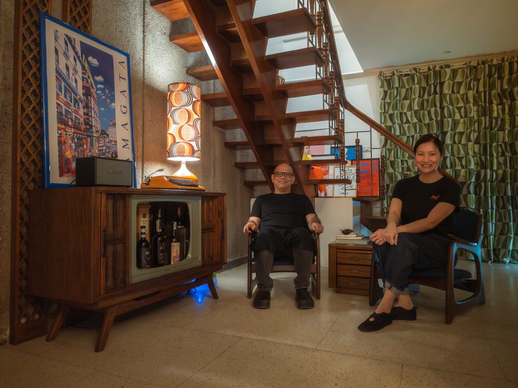 Nats and Ethel relaxing in the vintage living room with staircase behind them